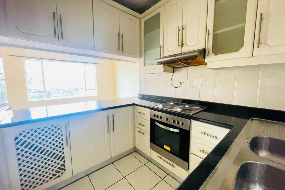 A functional kitchen featuring built-in cabinetry, granite countertops, a built-in oven with hob, and a double bowl sink.
