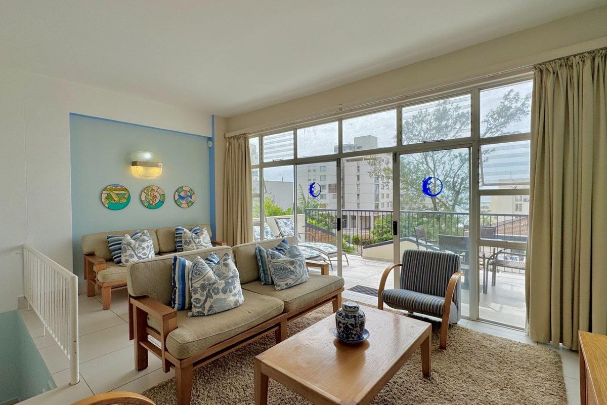 Bright living room featuring large sliding glass doors that provide natural light and direct access to an outdoor balcony area.