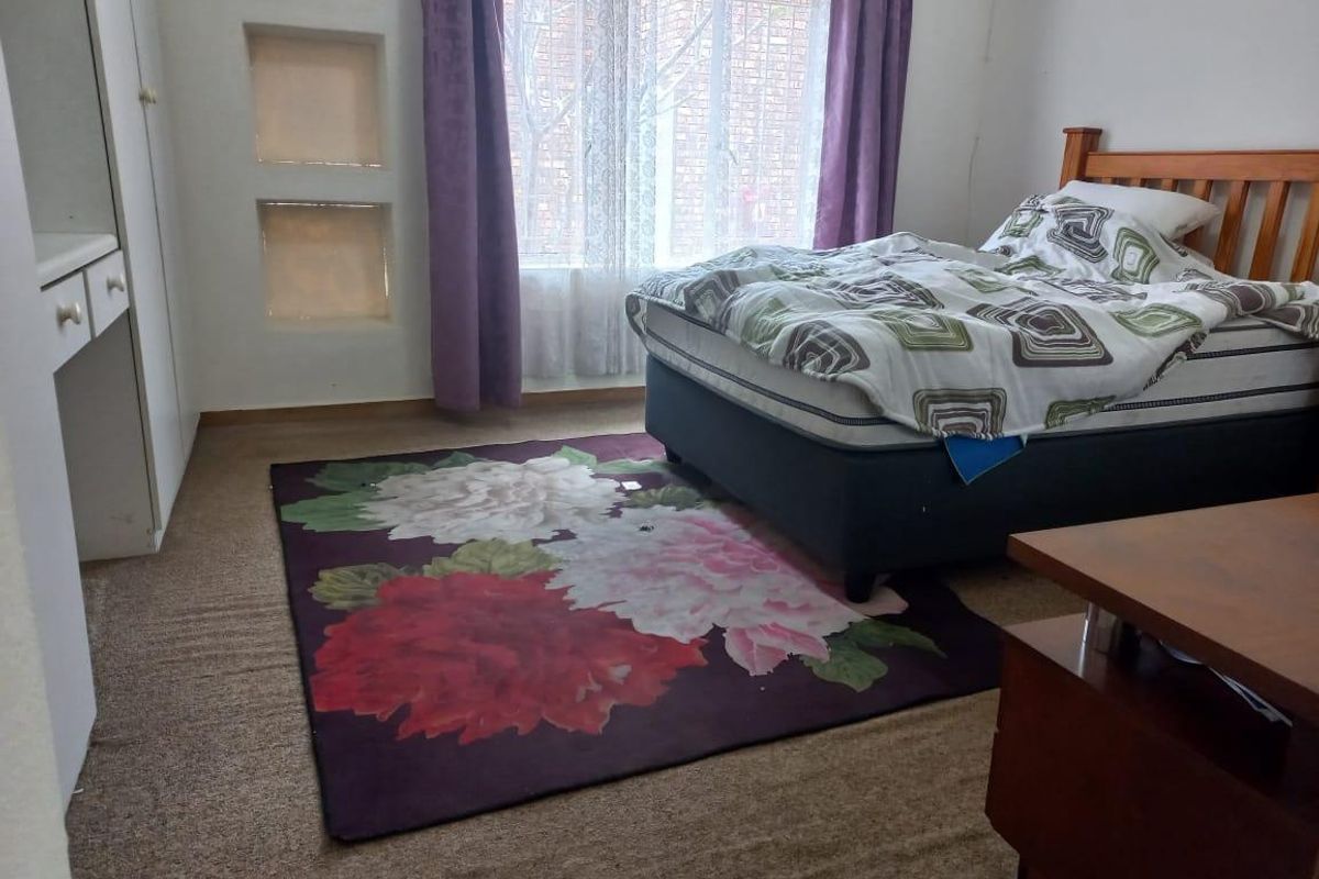 A bedroom featuring built-in wardrobe storage, recessed wall niches, and carpeted flooring, providing a functional space within the retirement village unit.