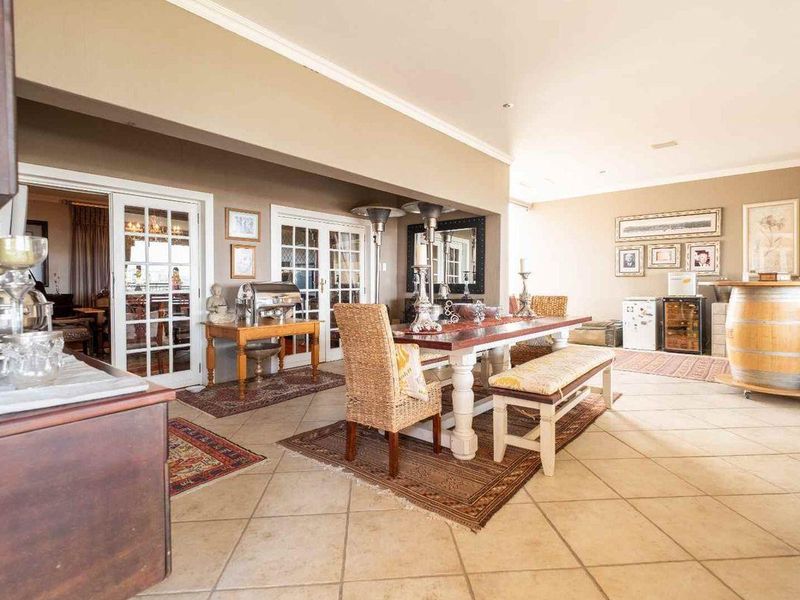 Spacious dining area featuring tiled flooring, crown molding, and multiple sets of french doors providing natural light and access to adjacent spaces.