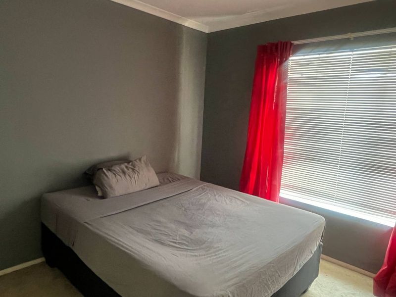 A bedroom featuring grey walls, window blinds, and coving, providing a neutral base for potential interior updates.