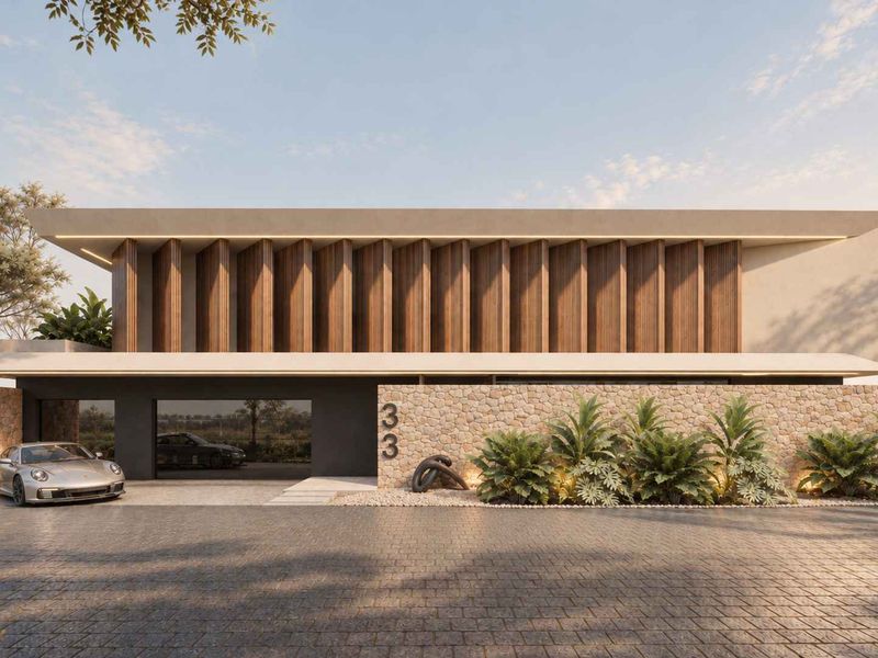 Modern architectural front facade featuring stone cladding, timber louvres, and a paved driveway with integrated garage access.