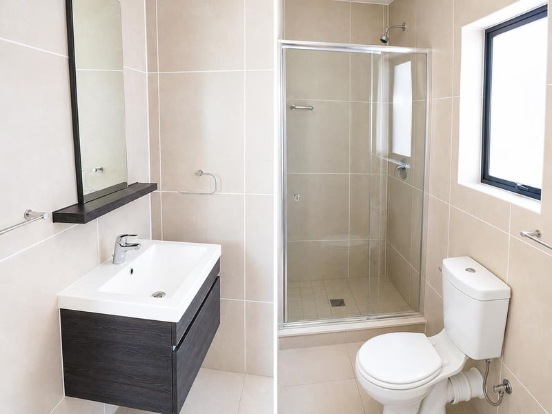Modern bathroom featuring a floating vanity, glass-enclosed shower, and neutral wall tiling, presenting a clean and functional layout.