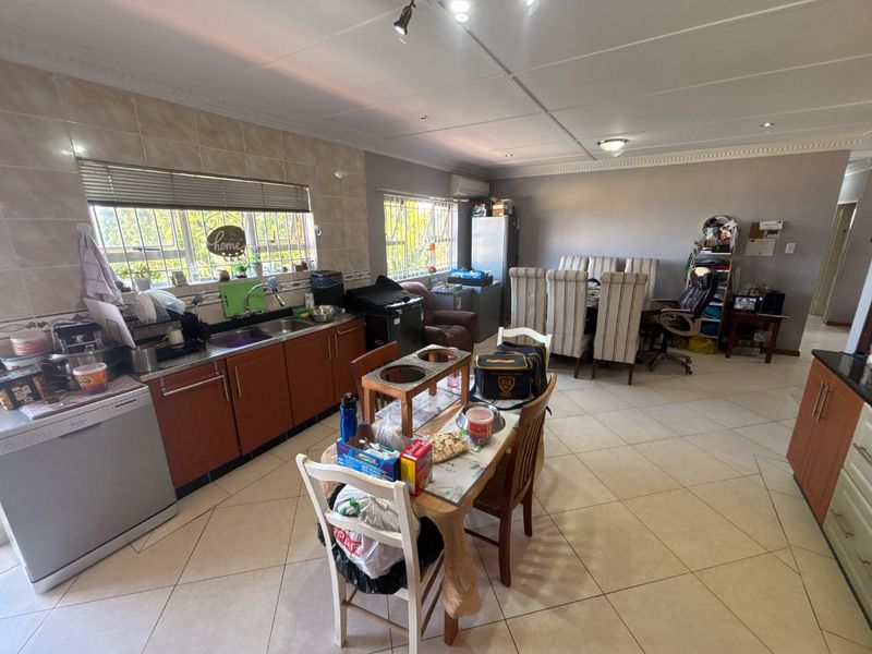 Spacious open-plan kitchen and dining area featuring tiled flooring, ample cabinetry, and a functional layout suitable for family living.