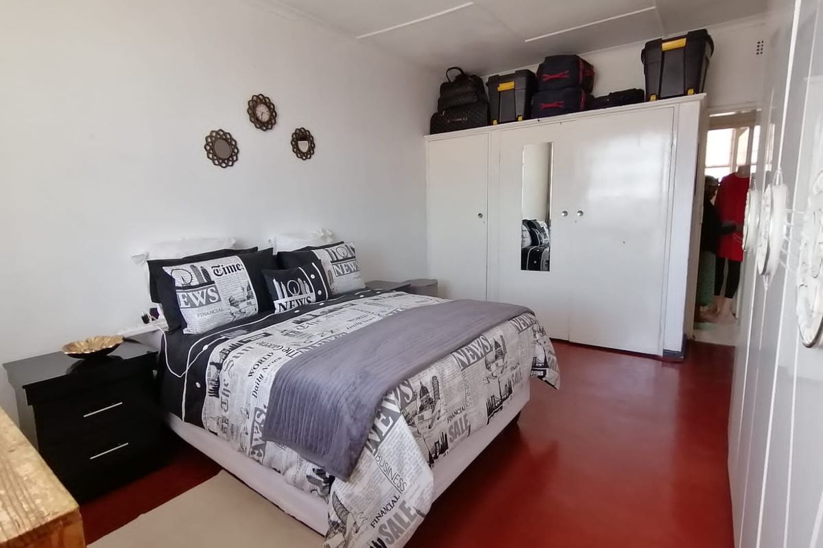 A bedroom featuring built-in white cabinetry and painted concrete flooring, offering functional storage space.