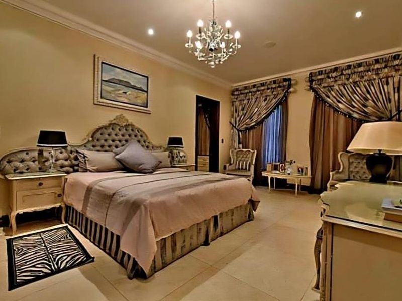 A spacious, well-maintained bedroom featuring tiled flooring, coved cornicing, and elegant lighting fixtures, creating a comfortable and refined sleeping environment.
