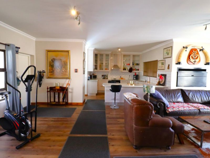Spacious open-plan living area featuring a modern kitchen with island, laminate flooring, and a built-in fireplace, creating a comfortable and functional living space.