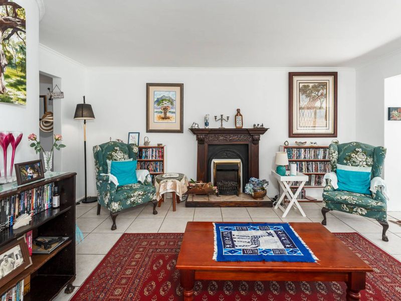 A cozy living room featuring a traditional fireplace with a decorative mantelpiece and neutral tiled flooring.