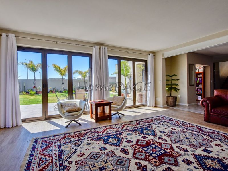 Spacious living room featuring large sliding glass doors that provide abundant natural light and direct access to the outdoor patio and garden area.