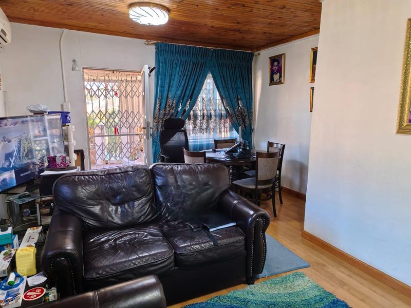 Living room featuring timber ceiling, laminate flooring, and direct access to an exterior security gate.