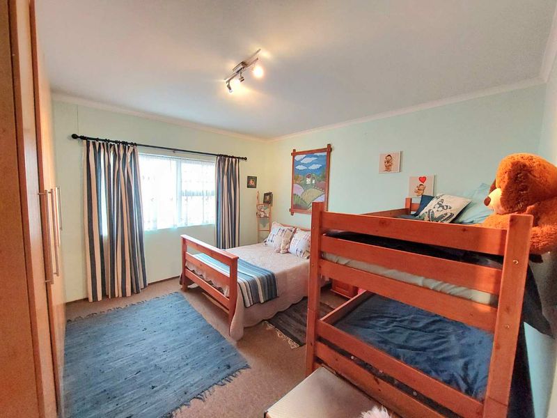 A functional bedroom featuring a built-in wardrobe, neutral wall finishes, and a ceiling-mounted light fixture, providing a comfortable and practical living space.