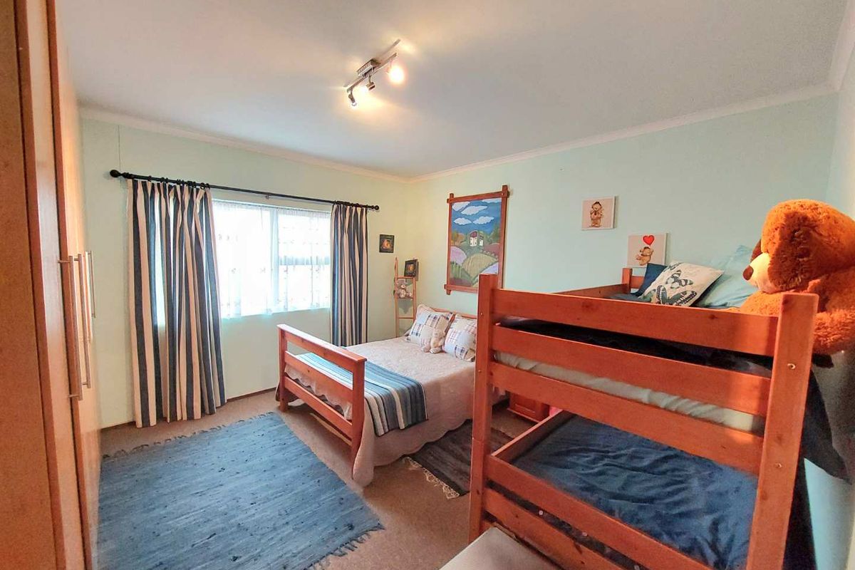 A functional bedroom featuring a built-in wardrobe, neutral wall finishes, and a ceiling-mounted light fixture, providing a comfortable and practical living space.