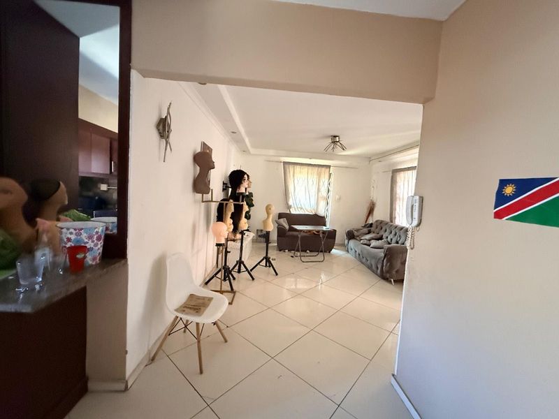 Open plan living area featuring tiled flooring and an intercom system, providing a functional space connecting to the kitchen area.