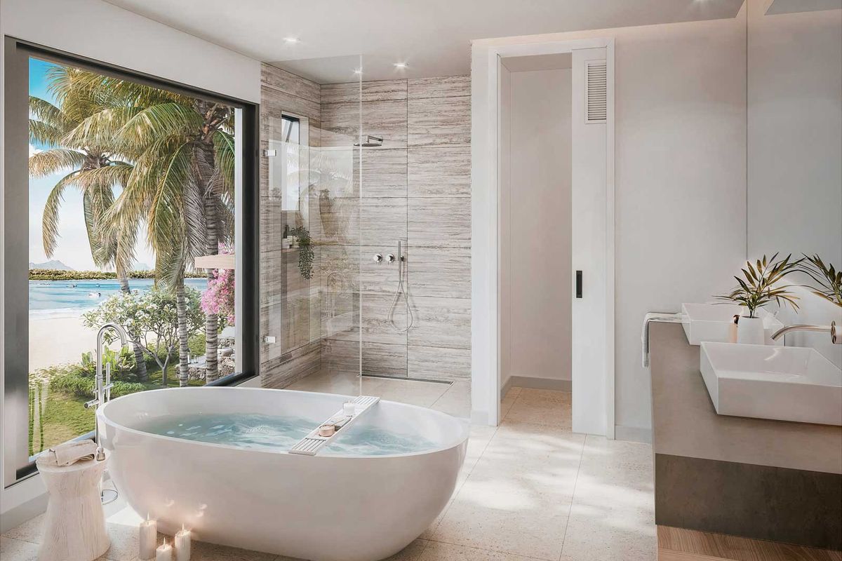 Modern luxury bathroom featuring a freestanding soaking tub, walk-in glass shower, and dual vanity sinks with scenic tropical beach views.