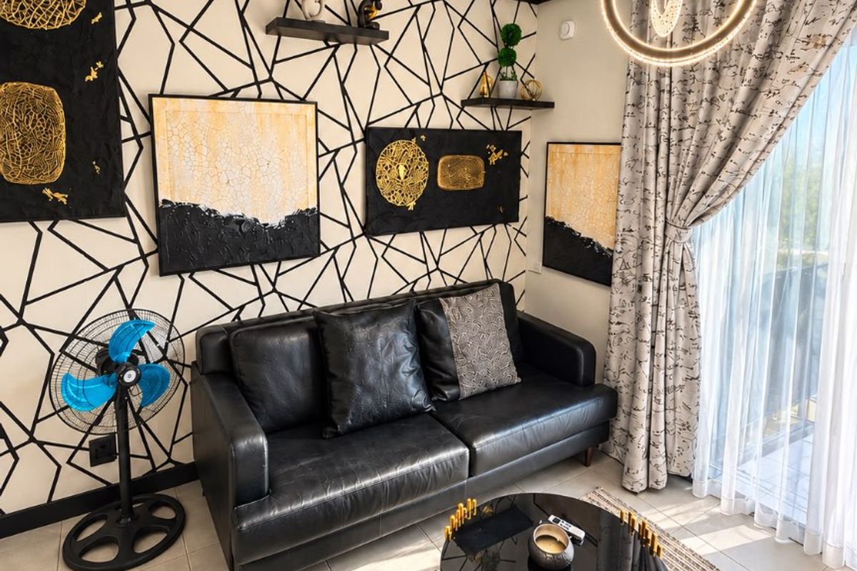 A well-lit living room featuring tiled floors, modern pendant lighting, and a sliding glass door leading to an outdoor area.