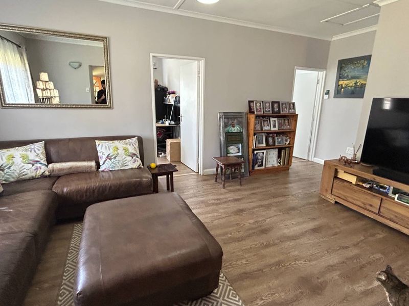 A comfortable living room featuring durable laminate flooring and neutral wall tones, providing a functional and inviting space for relaxation.