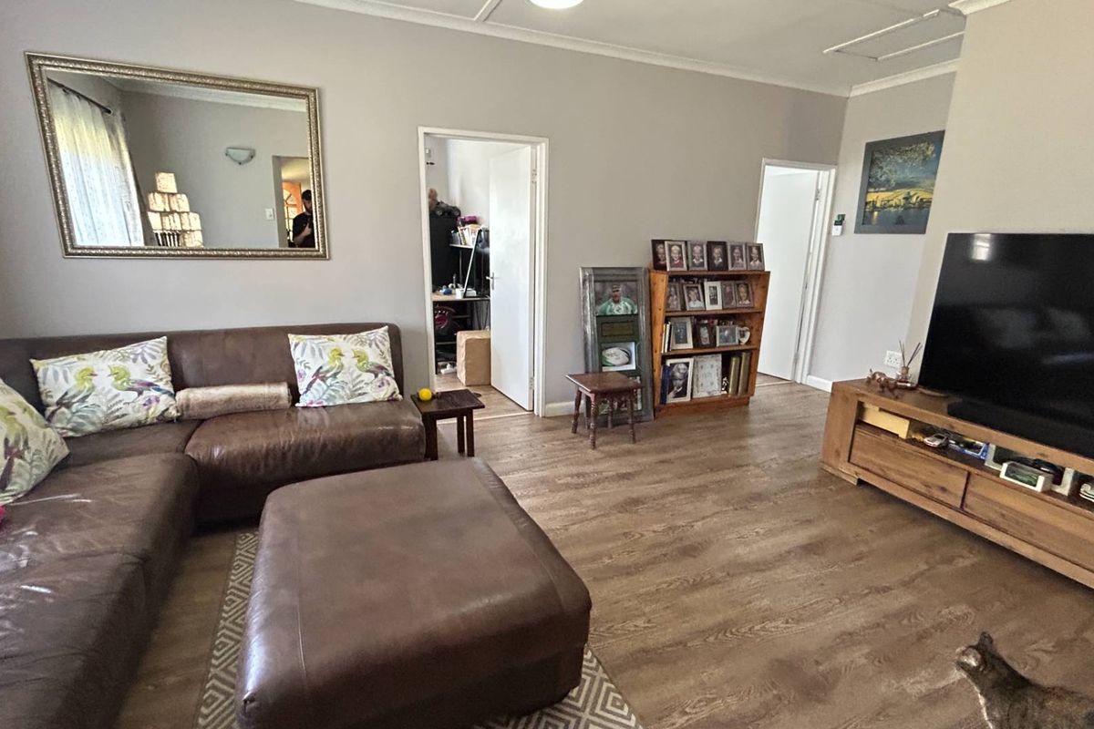 A comfortable living room featuring durable laminate flooring and neutral wall tones, providing a functional and inviting space for relaxation.