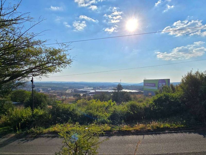 A wide-angle view overlooking a residential landscape with distant commercial buildings and a large billboard visible in the background.