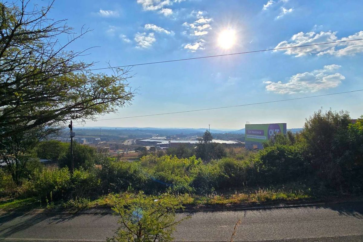 A wide-angle view overlooking a residential landscape with distant commercial buildings and a large billboard visible in the background.