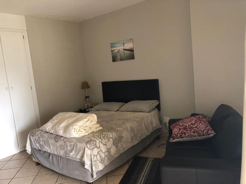 A functional bedroom featuring tiled flooring and a built-in wardrobe, offering a neutral space ready for personalization.