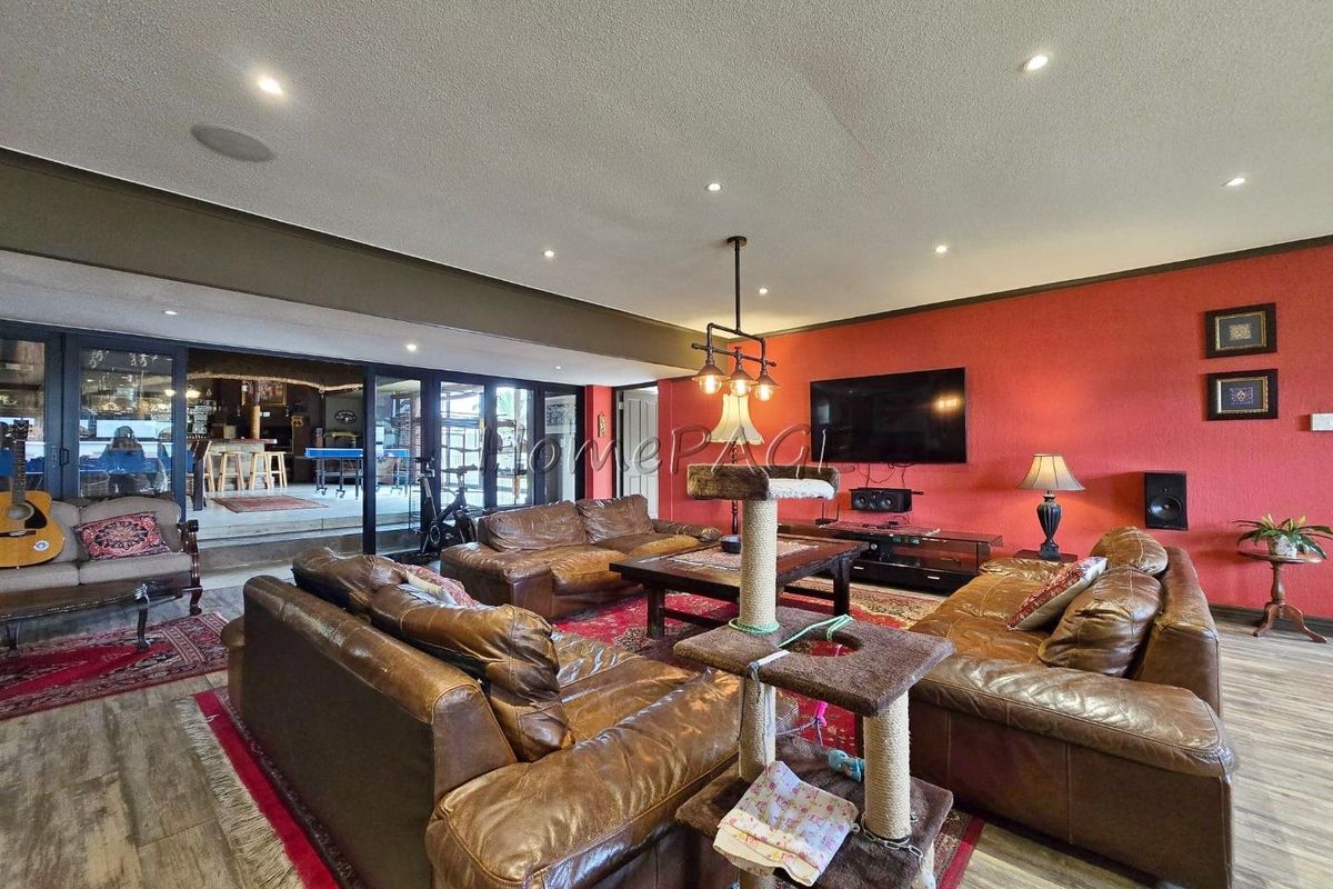 Spacious living room featuring recessed lighting, wood-look flooring, and large sliding glass doors providing seamless access to an outdoor entertainment area.