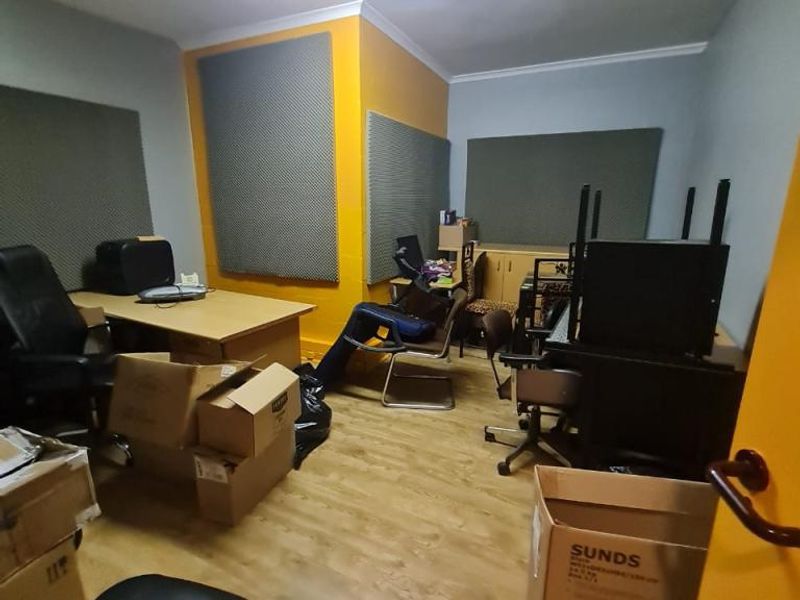 A functional office space featuring laminate flooring, acoustic wall panels, and integrated ceiling lighting, suitable for a professional work environment.