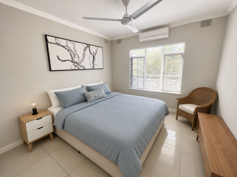 A well-maintained bedroom featuring tiled flooring, crown molding, a ceiling fan, and a split-system air conditioner for climate control.