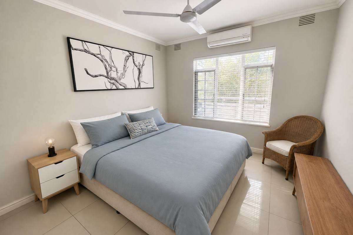 A well-maintained bedroom featuring tiled flooring, crown molding, a ceiling fan, and a split-system air conditioner for climate control.