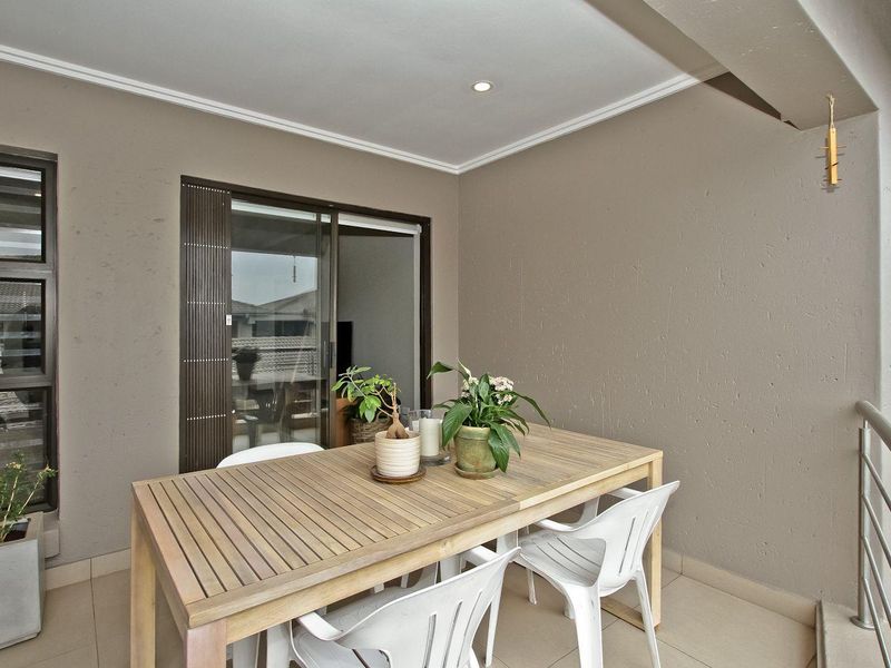 A covered balcony featuring tiled flooring, recessed lighting, and a sliding glass door providing access to the interior living space.