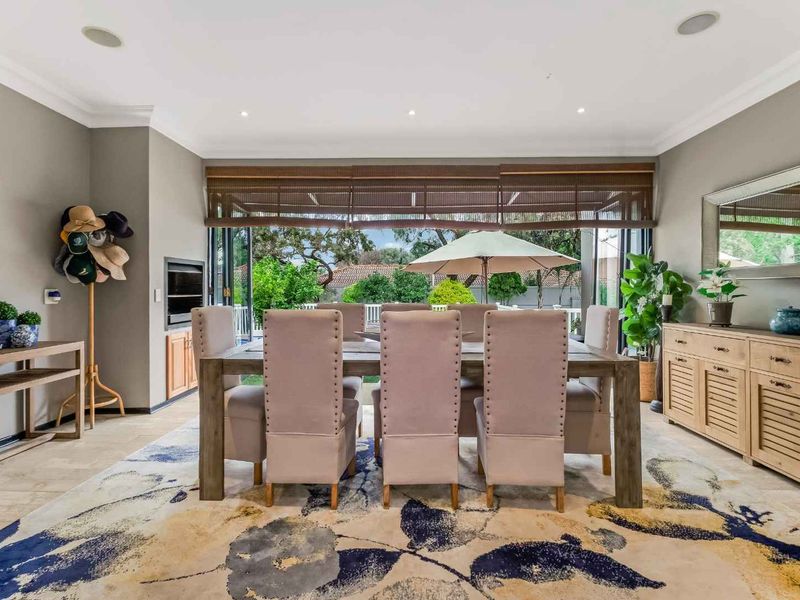 Spacious dining room featuring tiled flooring, recessed downlights, and large bi-fold doors that open to the outdoor area, creating a seamless indoor-outdoor flow.