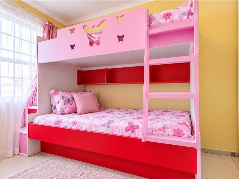 A bright bedroom featuring tiled flooring, a large window with natural light, and a built-in wardrobe.