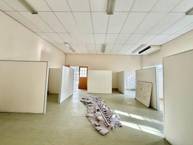 Open-plan office space featuring a suspended ceiling, integrated air conditioning, and modular partition walls, providing a flexible layout for professional use.