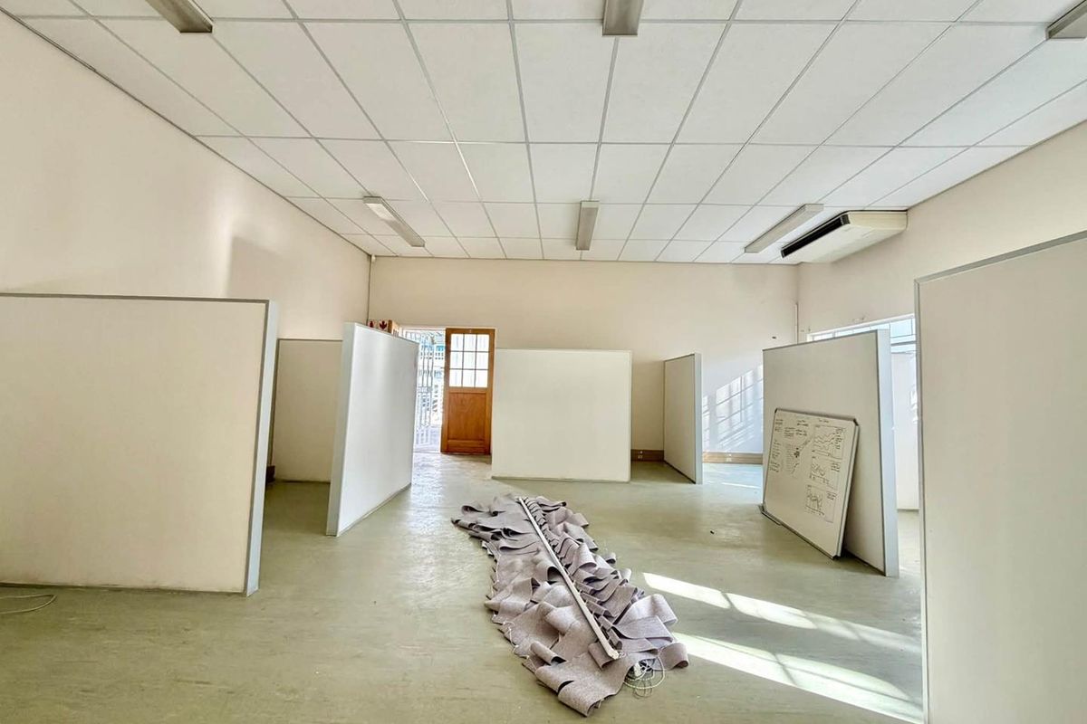 Open-plan office space featuring a suspended ceiling, integrated air conditioning, and modular partition walls, providing a flexible layout for professional use.