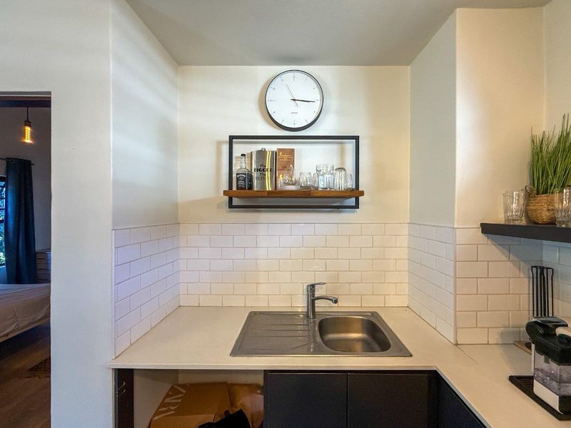 A compact scullery or prep area featuring a stainless steel sink, modern mixer tap, and clean white subway tile backsplash.