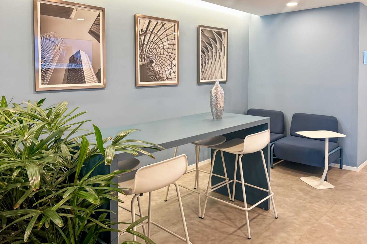A modern office breakout area featuring recessed ceiling lighting and tiled flooring, designed for collaborative work or casual meetings.