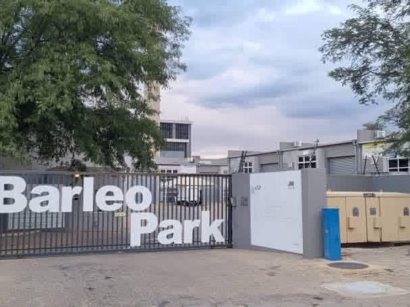 Front entrance view of Barleo Park office and industrial complex featuring secure gated access, perimeter walling, and industrial unit facades.