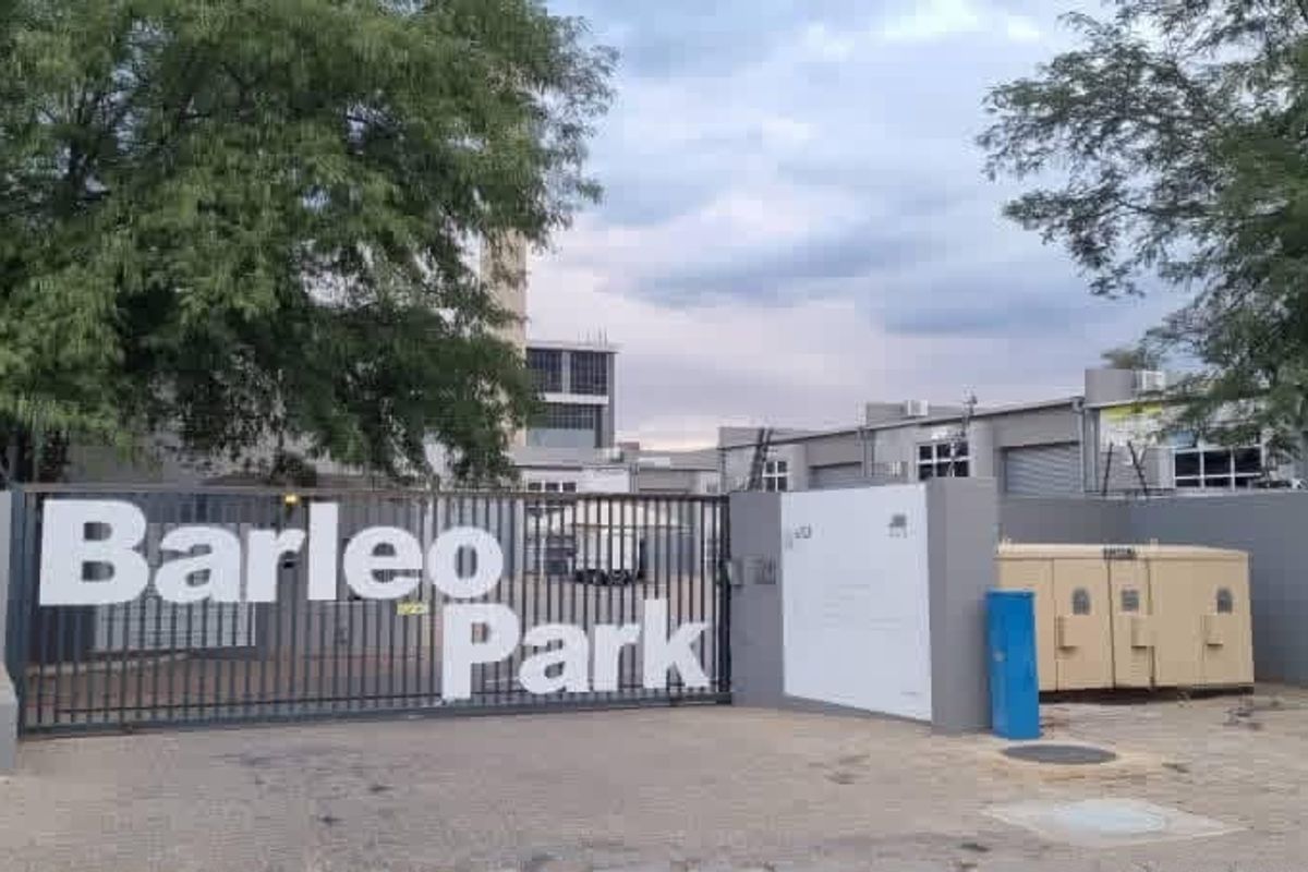 Front entrance view of Barleo Park office and industrial complex featuring secure gated access, perimeter walling, and industrial unit facades.