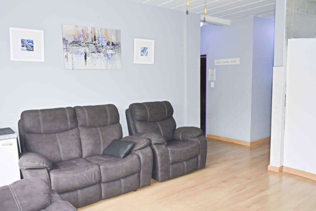 A living room area featuring light-toned laminate flooring and neutral wall finishes, providing a clean and functional space.