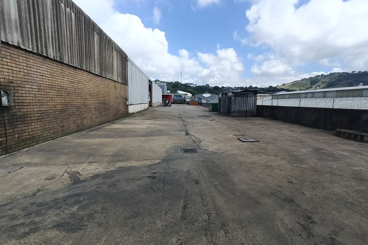 Expansive industrial concrete yard area featuring perimeter brick and metal cladding walls, suitable for heavy vehicle access and outdoor storage.