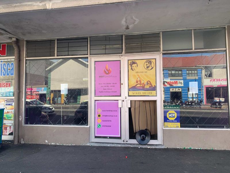 Retail shopfront featuring large display windows and a double glass entrance door with visible damage to the glass and lower facade.