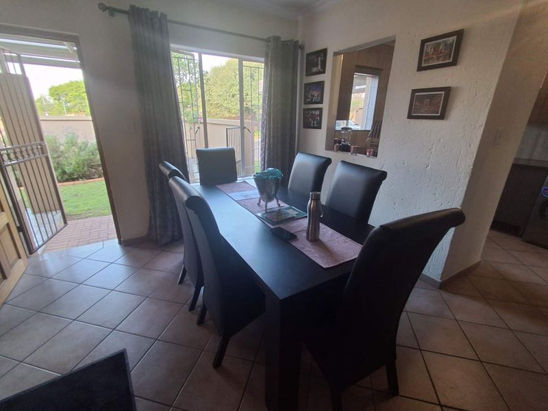 Dining area featuring tiled flooring, a pass-through window to the kitchen, and direct access to the outdoor patio through a sliding glass door.