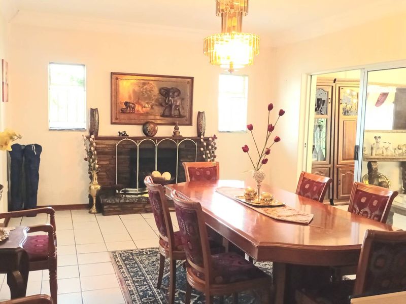 A dining room featuring tiled flooring, a traditional fireplace, and a sliding glass door leading to an adjacent space.