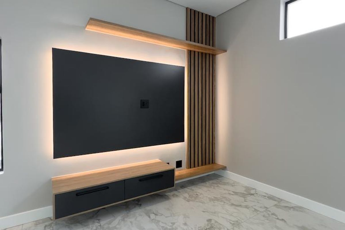 Modern living room featuring a custom floating media console, integrated LED accent lighting, timber slat wall paneling, and polished marble-look floor tiles.