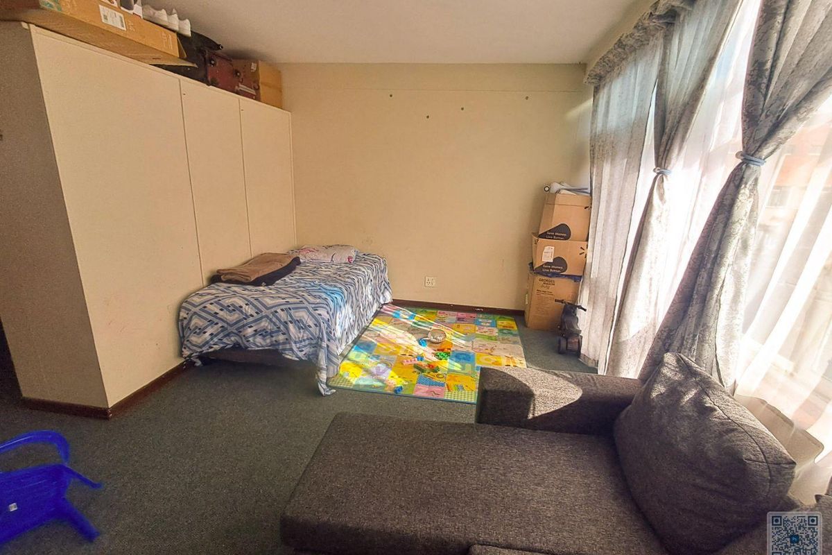 A bedroom featuring built-in cabinetry, carpeted flooring, and large windows allowing for natural light.