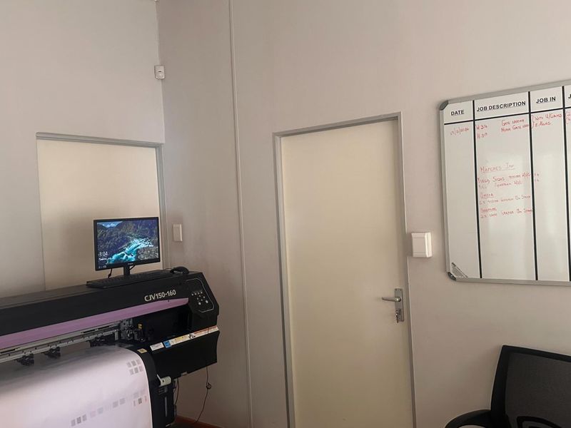 A functional office space featuring neutral walls, a standard internal door, and integrated electrical fixtures suitable for a professional work environment.