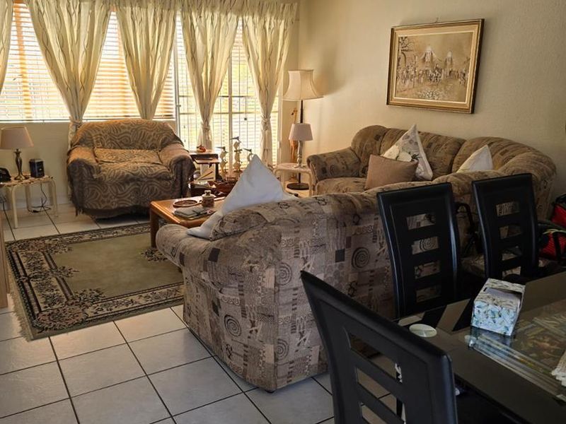 Open plan living and dining area featuring tiled flooring and access to the exterior through a sliding glass door.