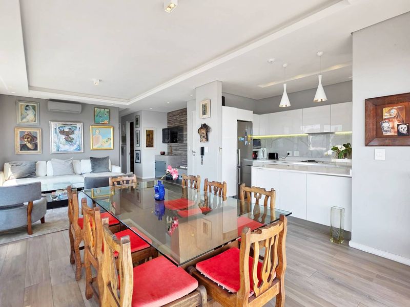 Spacious open-plan living, dining, and kitchen area featuring modern cabinetry, recessed lighting, and neutral finishes in a contemporary penthouse setting.