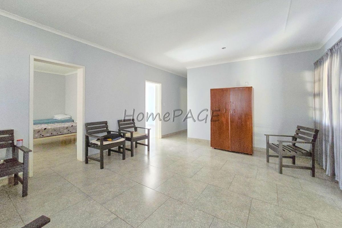 Spacious living area featuring neutral tiled flooring and coved ceilings, providing a clean and functional base for interior design.
