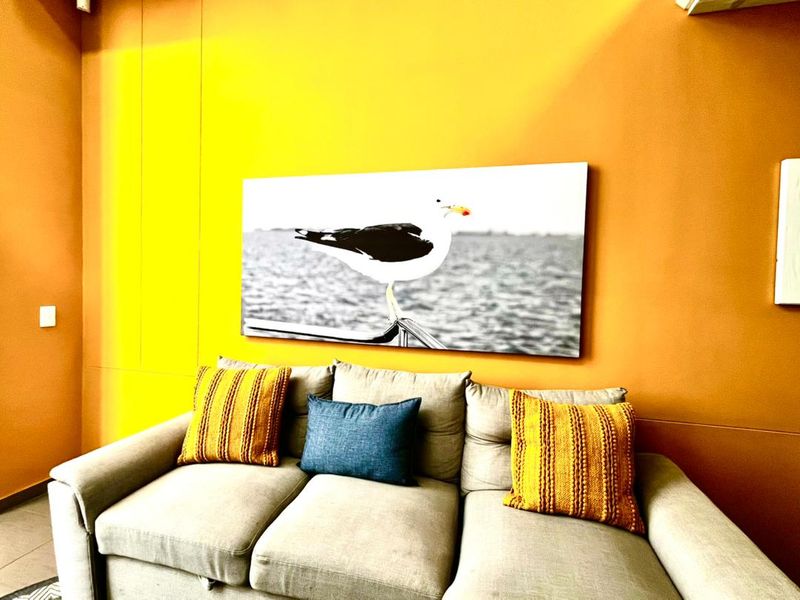 A living room area featuring vibrant orange and yellow wall finishes, providing a bold backdrop for the space.