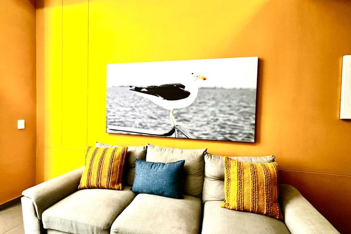 A living room area featuring vibrant orange and yellow wall finishes, providing a bold backdrop for the space.